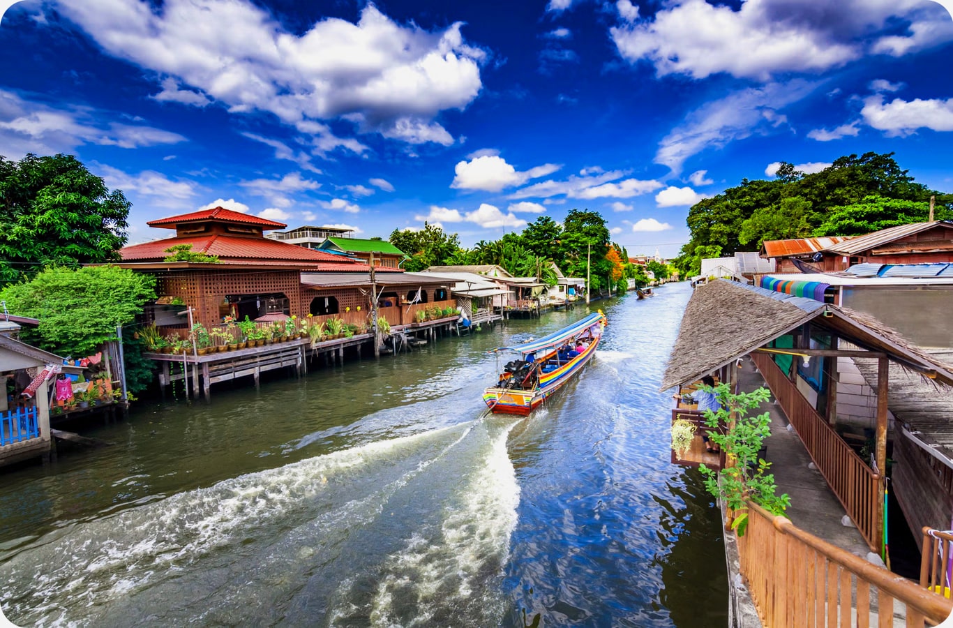 Bangkok canal with stilted houses and a long-tail boat, a must-see place to visit in Thailand.