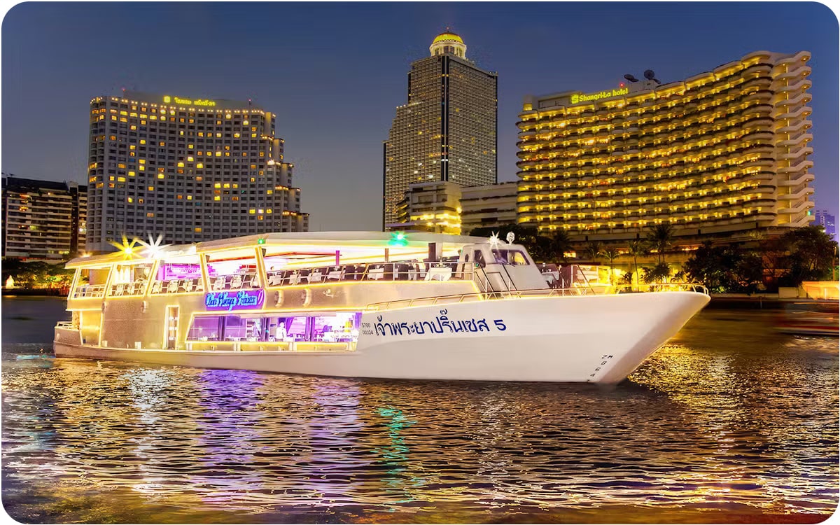 Chao Phraya Dinner Cruise in Bangkok with a luxurious illuminated boat floating on the river, surrounded by iconic city hotels at night – a must-visit attraction in Thailand.