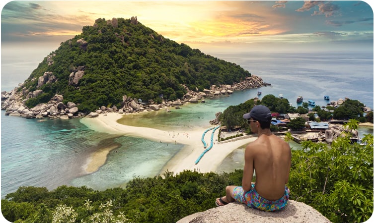 Relaxing beach scene with longtail boats in Koh Phangan, a must-see place in Thailand.