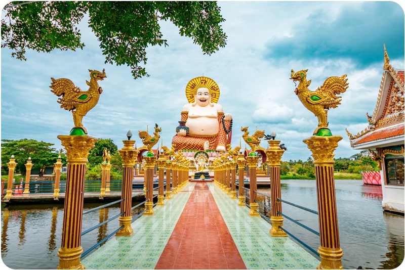 A large golden Buddha statue overlooking a lake in Koh Samui, a must-visit place in Thailand.