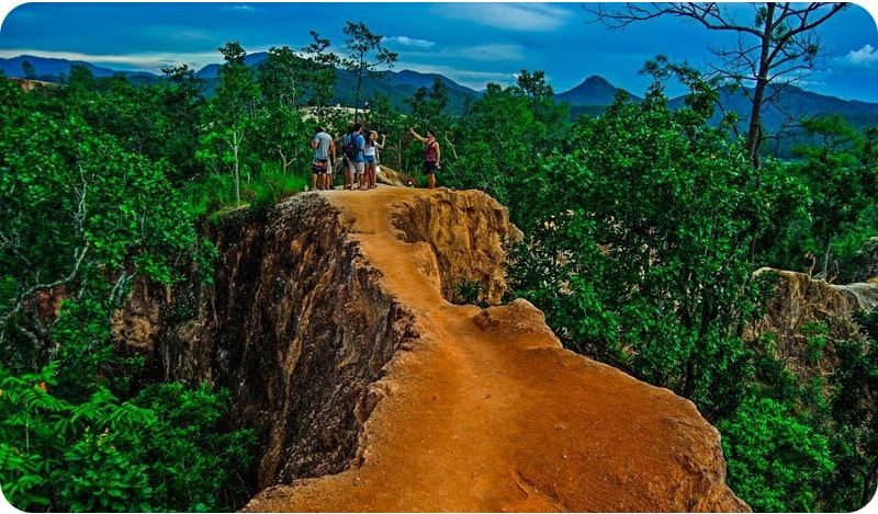 A group of friends exploring the Pai Canyon, a popular tourist destination in Thailand.