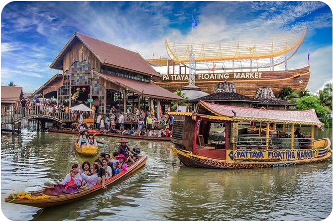 Colorful boats and vendors at the Pattaya Floating Market, a popular tourist destination in Thailand.