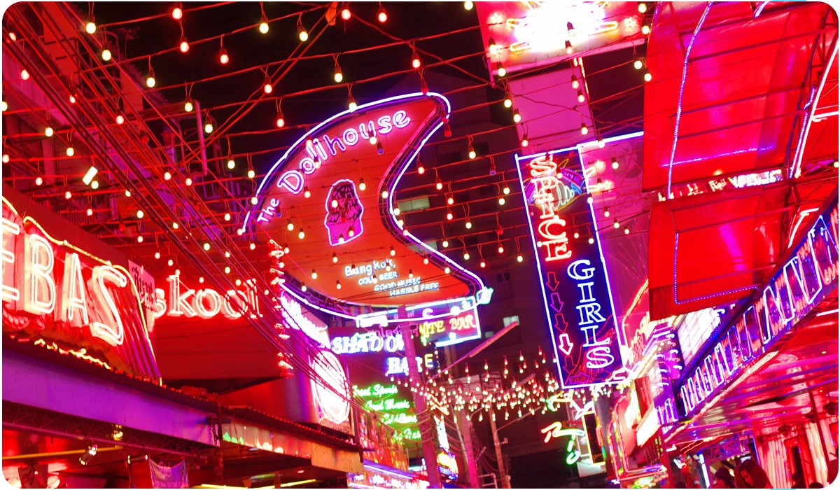 Neon signs illuminate the bustling Soi Cowboy street in Bangkok, one of Thailand's most visited tourist attractions, showcasing colorful nightlife.